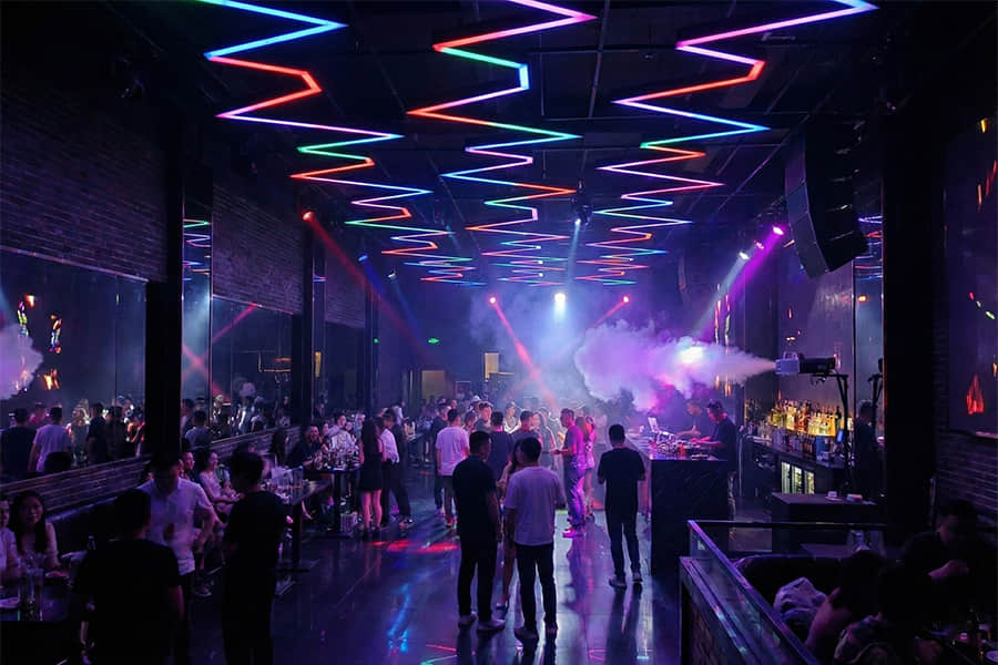 Atmospheric lighting effects created using linear extrusion lenses in nightlife and entertainment spaces